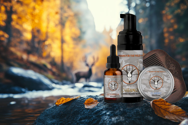 Beard Care Bundle resting on a rock at the edge of river in a fall scene with a deer in the background. Beard Oil, Beard Butter, Beard Wash and a Comb.