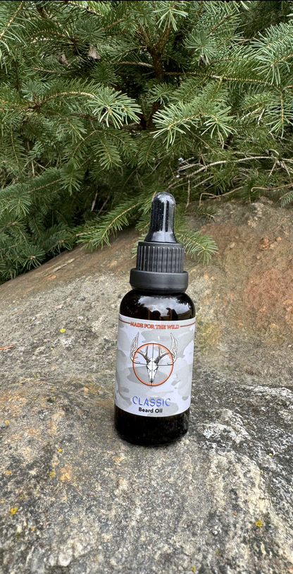 Classic Beard Oil Made for the Wild in Canada. On a rock with a cedar tree branches